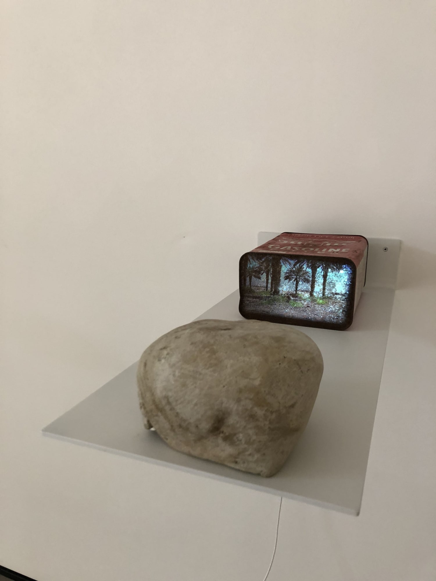 Pipelines And Sinkholes #2, 2019 White Aluminum 11" x 26" Floating Shelf ,Rusted 1 gallon gasoline can ,video projector with usb, 3:00 single Channel video