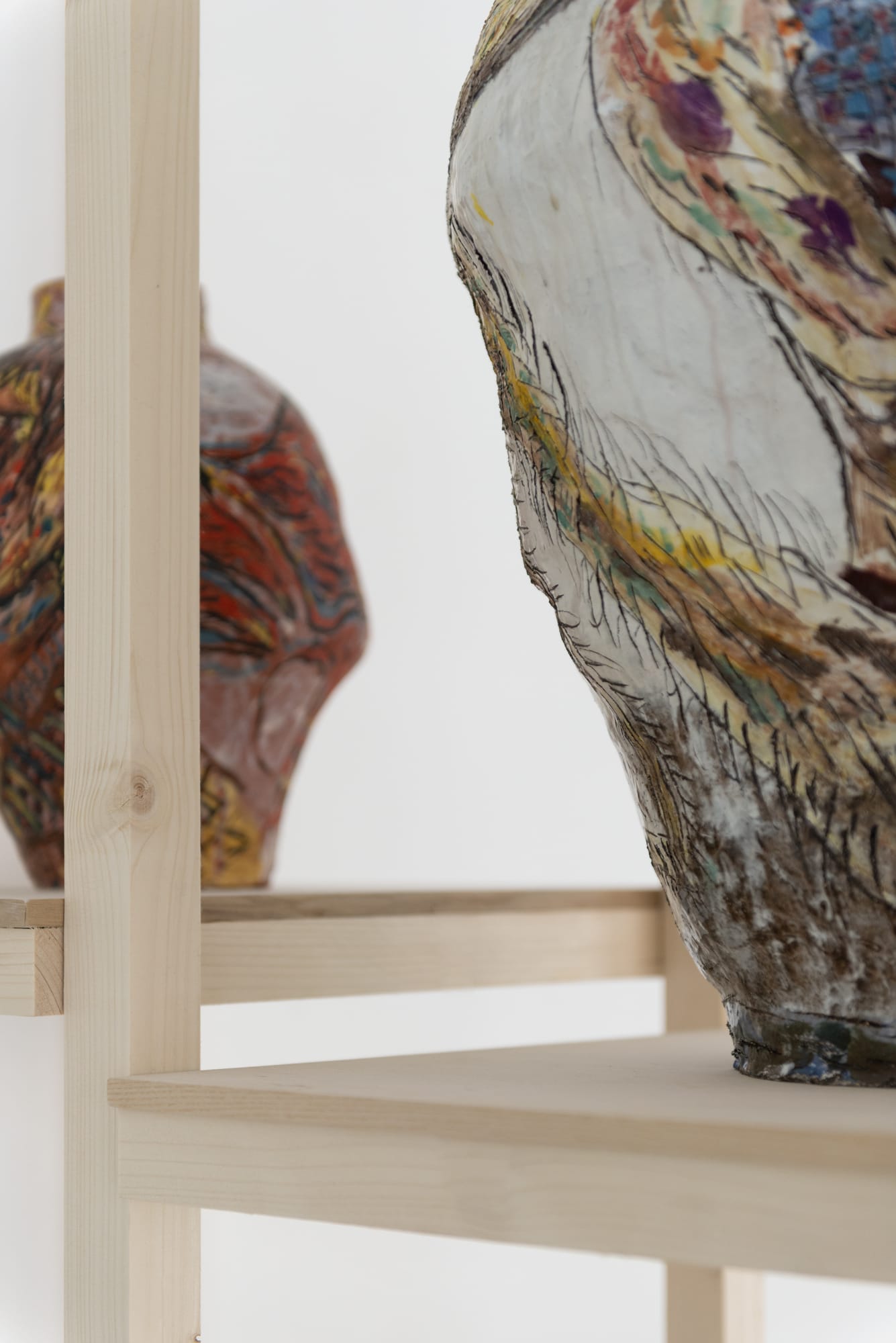 Detail of an installation from Karim Boumjimar’s Mouths, Vessels, Portals (2025), combining chalk drawings on canvas with ceramic forms.