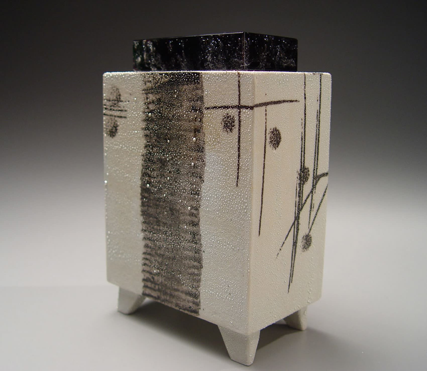 KONDO TAKAHIRO Black and white rectangular object with calligraphic design, glass lid and silver glaze 2007 Porcelain with black and metallic glazes and glass cover 6 7/8 x 4 1/2 x 2 3/4 inches Inv# 5131