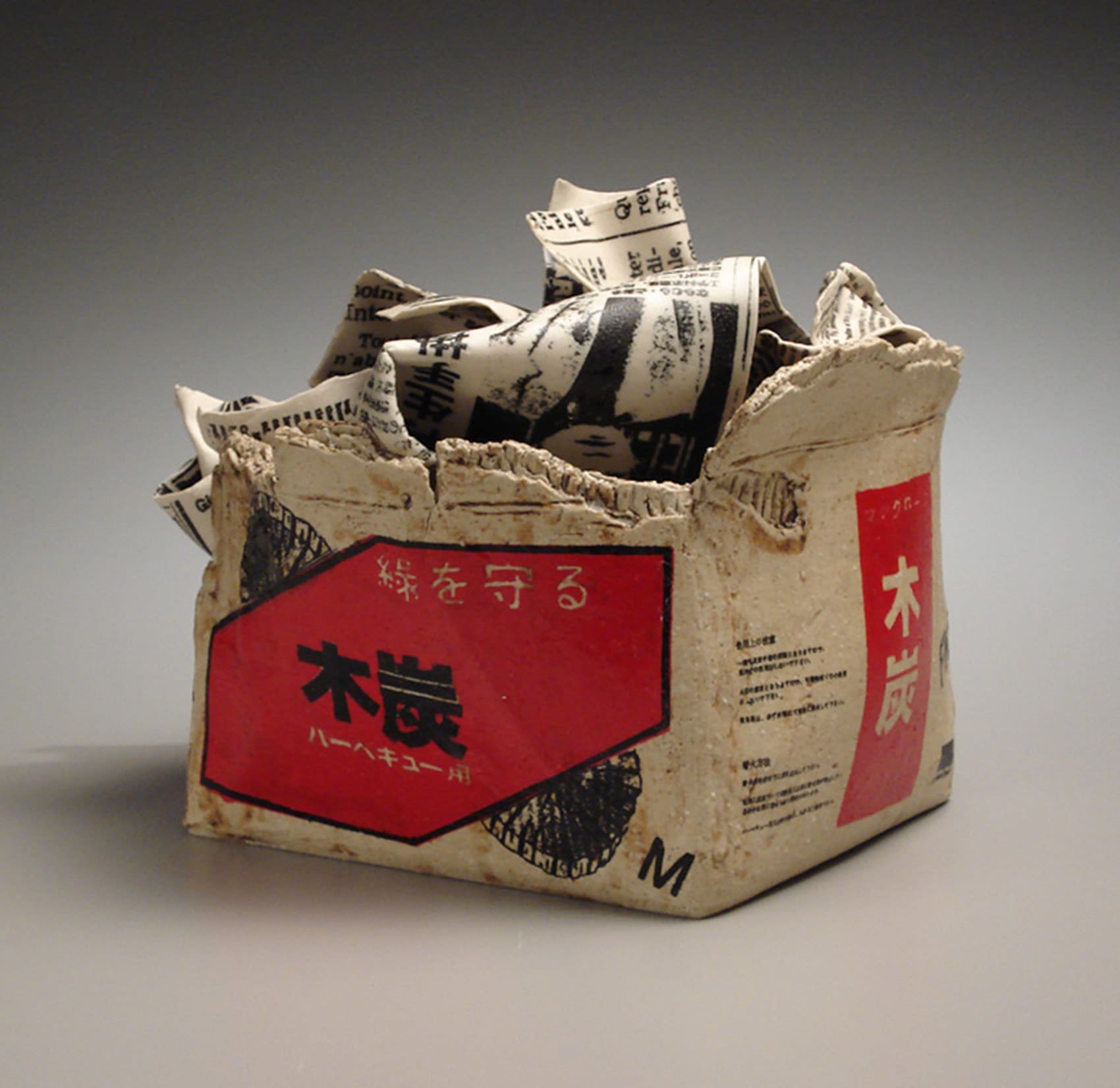 MISHIMA KIMIYO Porcelain sculpture of charcaol box filled with newspaper 2002 Stoneware with polychrome glazes 8 1/4 x 11 3/4 x 10 1/2 inches Inv# 4642