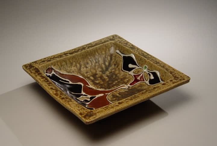 Kawai Kanjirô (1890-1960) Shallow square bowl with yellow (kiraku) glaze, abstracted design of a \"flower in hand\" with brown, black, white, red and green glazes outlined in trailed slip (tsutsugaki), ca. 1950 Stoneware 2 3/4 x 11 3/4 x 11 3/4 inches; Inv# 3902 SOLD