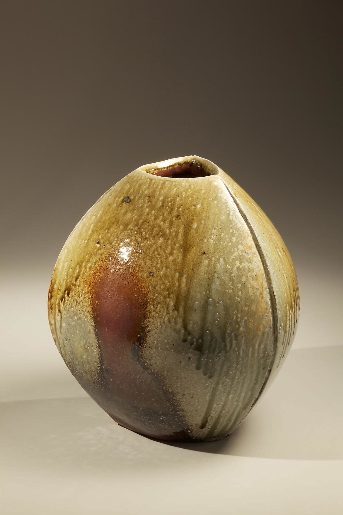 Rounded three-sided Tanba vessel with three scored \"seams\" and dripping natural ash and red akadobe glazing, 2010 Wood-fired stoneware 15 x 14 1/4 inches; Inv# 6890 SOLD