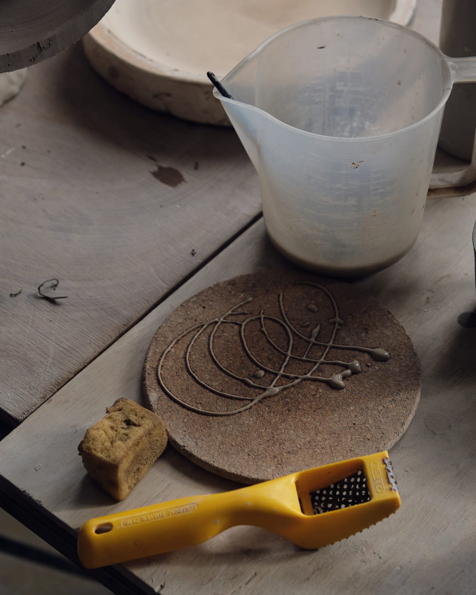 She quickly practices before applying her slip. She explains, slipware is part of the work whereas delftware is fired onto the pieces - both are methods she applies