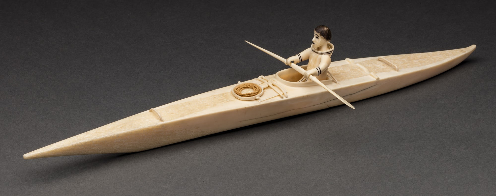 Lot 35 Attributed to SHEOKJUK OQUTAQ (1920-1982) m., KIMMIRUT/KINNGAIT (LAKE HARBOUR/CAPE DORSET), Kayaker, mid-late 1940s ivory, rope, black ink and inlay, 1.75 x 15.75 x 6.25 in (4.4 x 40 x 15.9 cm) Estimate: $2,500 — $3,500 Price realized: $4,800