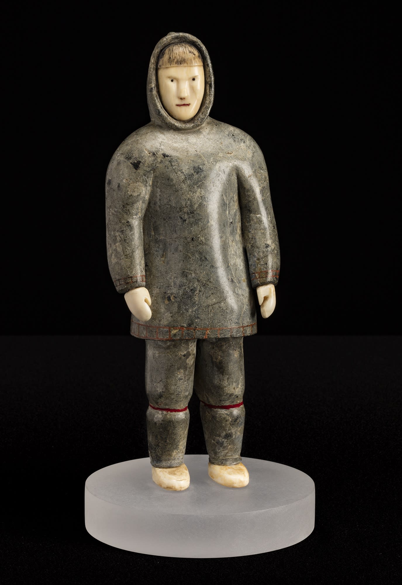 Lot 89 Possibly SHEOKJUK OQUTAQ (1920-1982) m., KIMMIRUT / KINNGAIT (LAKE HARBOUR / CAPE DORSET) Standing Man, mid 1950s stone, ivory, red inlay, and black colouring, 9.75 x 3.75 x 2.5 in (24.8 x 9.5 x 6.3 cm) not including lucite base Estimate: $4,500— $6,500