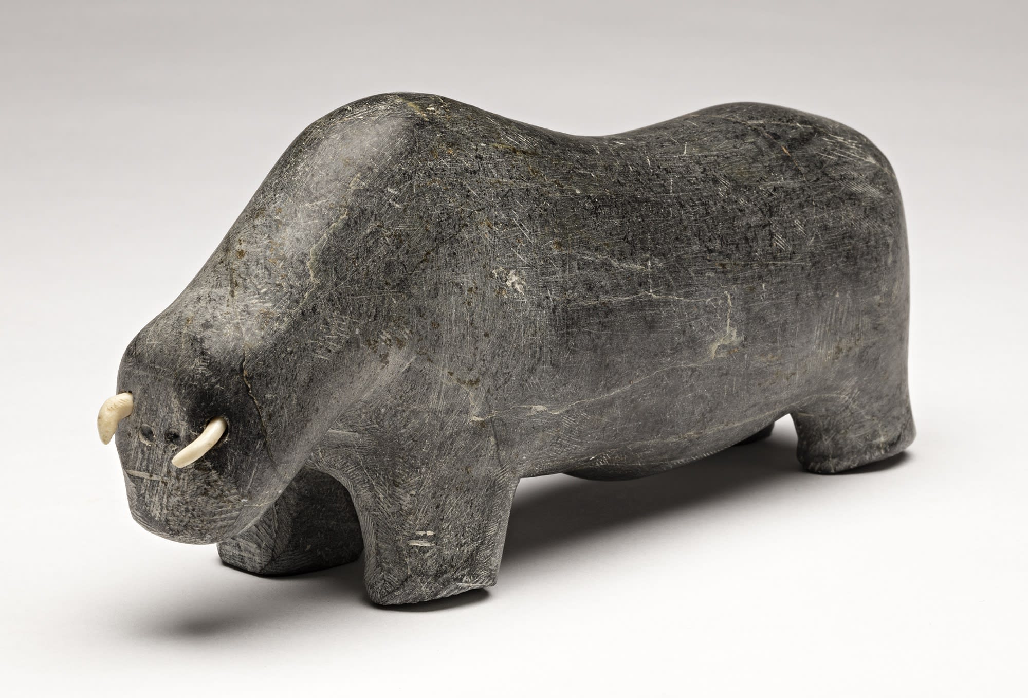 Lot 98 WILLIAM ANAUTALIK (1931-1987), QAMANI' TUAQ (BAKER LAKE) Muskox, early 1985 stone and antler, 3.25 x 7.5 x 2.5 in (8.3 x 19.1 x 6.3 cm) Estimate: $1,200— $1,800 price realized: $1,200