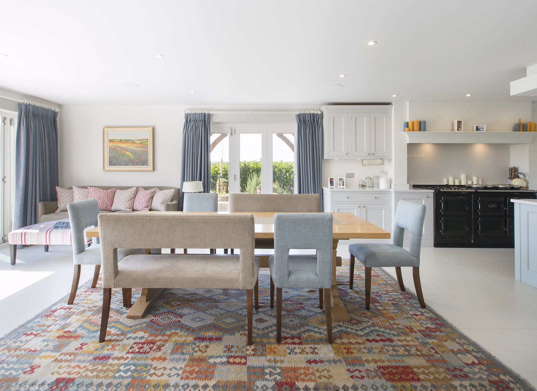 A painting by local artist Edward Noott is the backdrop in this Cotswolds open plan kitchen & dining room