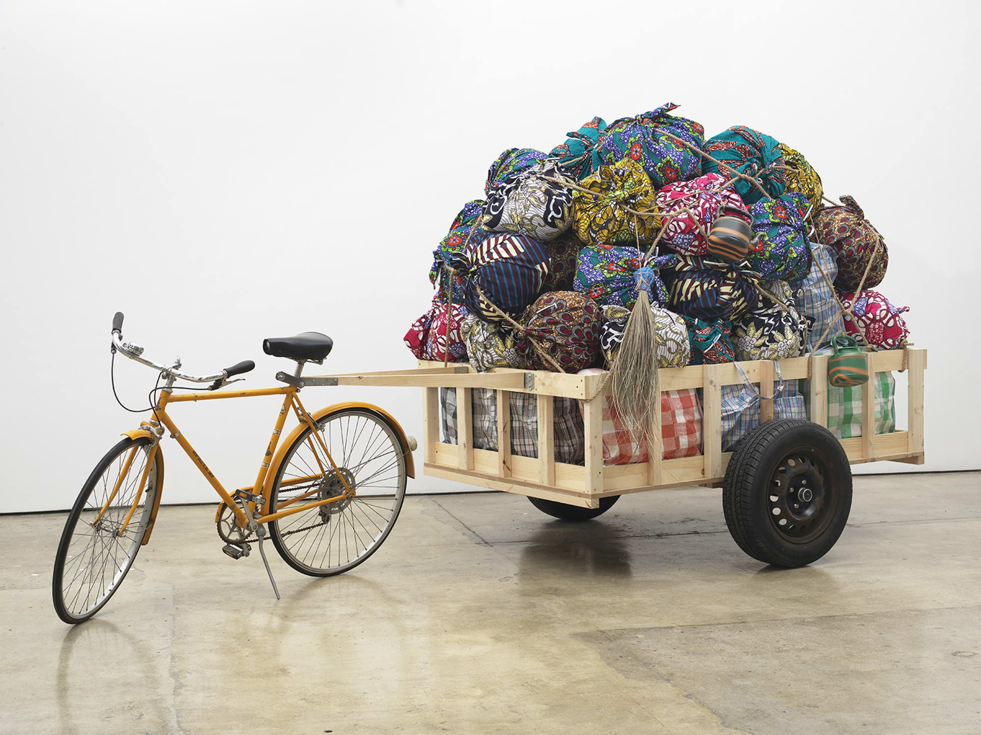 Barthélémy Toguo Exodus, 2019 Bicycle, trailer, fabric, plastic jugs, broom 72 x 152 x 64 inches (182.9 x 386.1 x 162.6 cm)