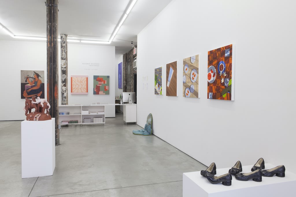 Installation view of "Buscando Recuerdos" group exhibition, ceramic sculpture on pedestal in foreground and color paintings by assorted artists on wall in background