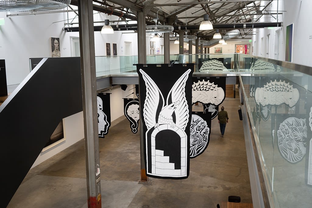 black and white embroidered banners hung in the atrium of Minnesota Street Projects