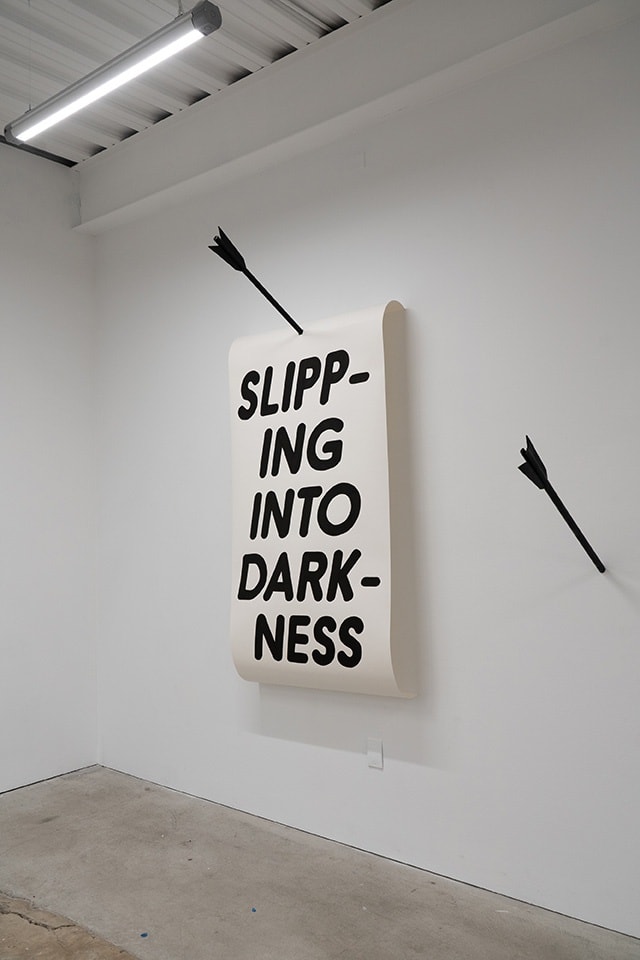 text artwork hung on white wall