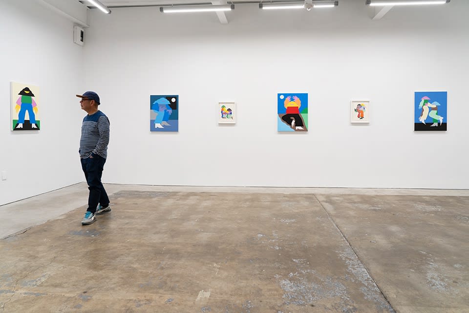 Installation view of Marbie's solo show "Good Love is Hard to Find," where images of abstracted figures, rendered in bright, color blocked hues, pose in various positions. A man on the left side of the photo stops to look at four small collages.