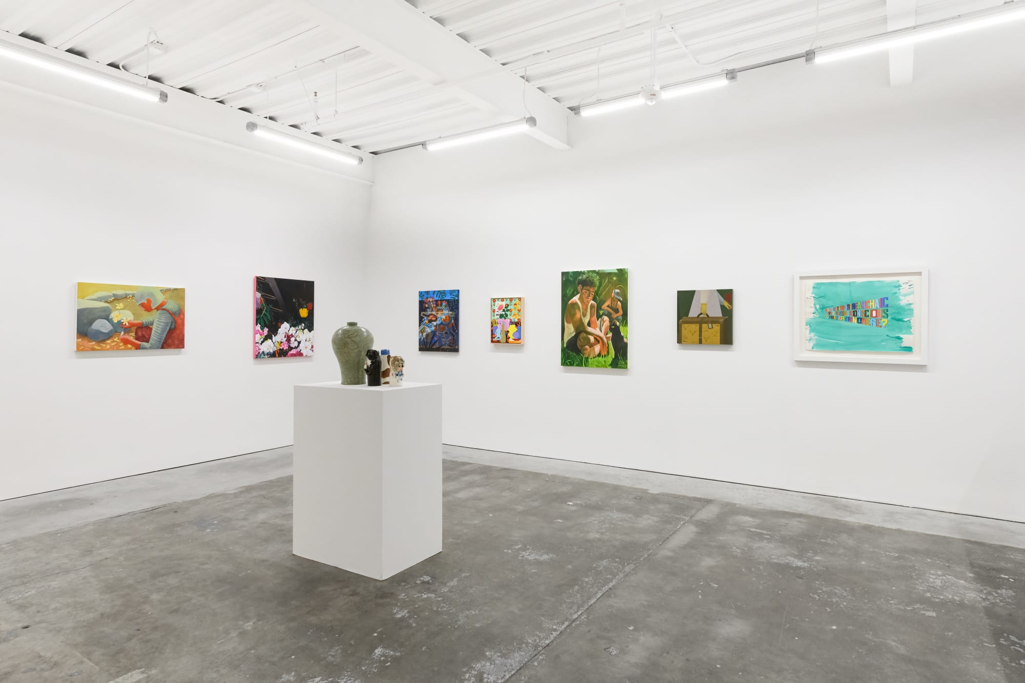 Installation shot of Hashimoto Contemporary's 10 Year Anniversary exhibition in the San Francisco gallery location. On the wall are numerous colorful paintings, and in the foreground there is a pedestal featuring works by David Heo and Katie Kimmel.