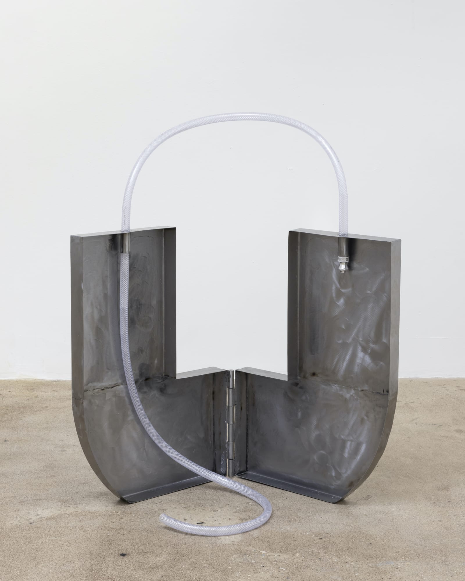 Alina Tenser (b. 1981) Water Carrier, 2023 Sheet metal, hinges, vinyl hose Overall: 39 x 34 1/2 x 34 inches; dimensions variable 99.06 x 87.63 x 86.36 cm