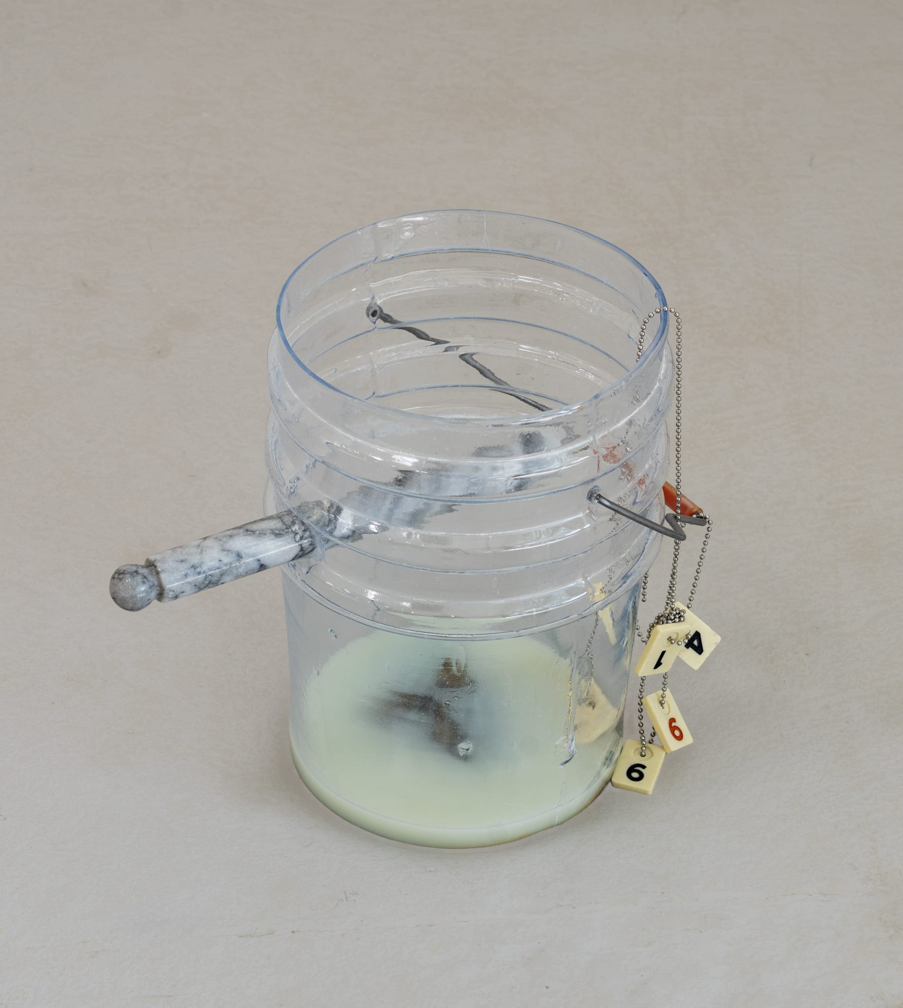 Catherine Telford Keogh Dust Gardens (Wet Bath), 2025 Mold-blown glass (Leaktite™ 2-gallon white plastic pail), found monarch butterfly, Green Titan® Window Cleaning Stain Remover, found marble paper towel holder, steel rod, sandblasted glass tube, nickel-plated chain, Lucite Rummy pieces 15 x 10¼ x 10¼ inches 38.1 x 26 x 26 cm