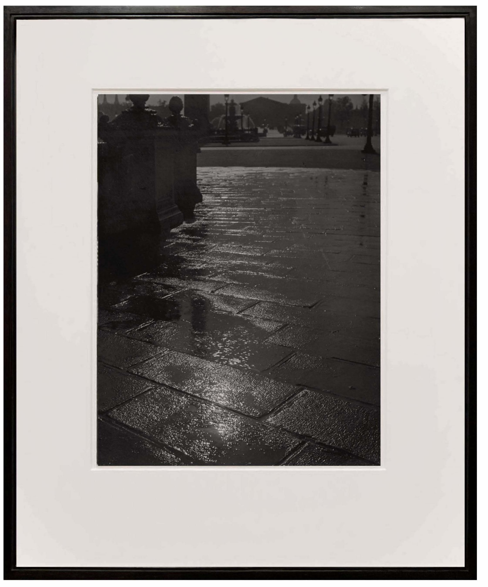 framed photograph of light reflection on rainy street at Place de la Concorde from Paris de Nuit by Brassai