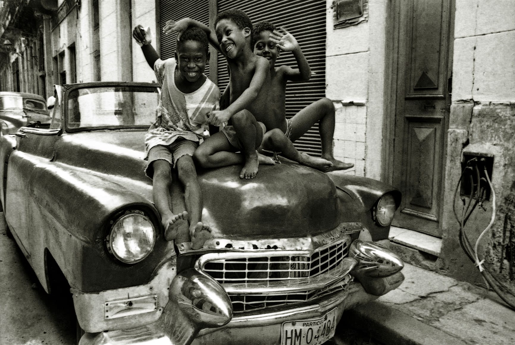 Lisette Solórzano Niños jugando sobre carro americano, 1998 baryta archival fine art print 16 x 20 inches