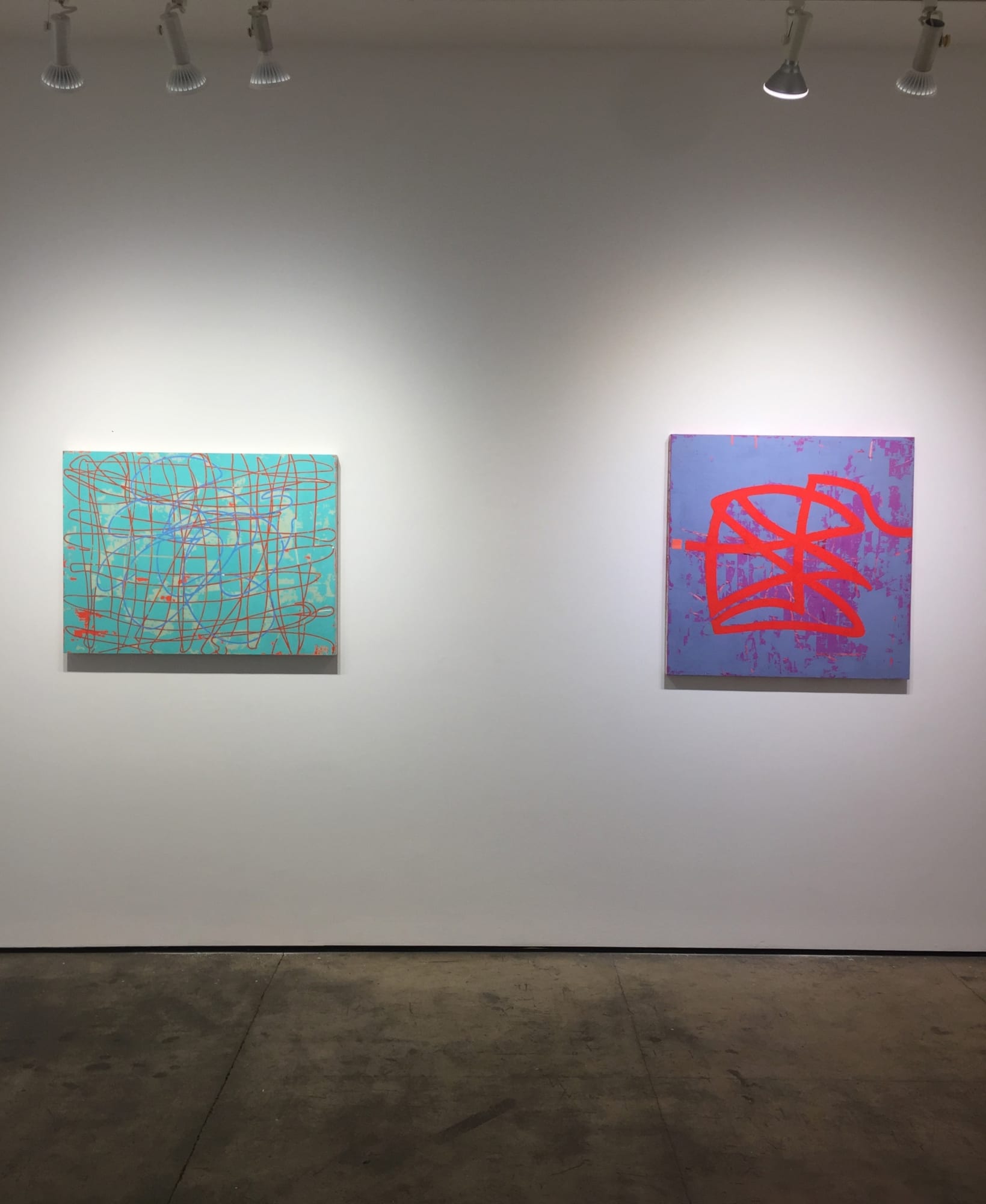 Gallery photograph of two abstract paintings on canvases in shades of violet, cyan and red.