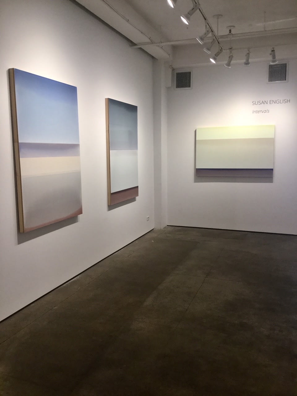 Installation shot of three tinted polymer on panels by Susan English. The works from left to right are "Intervals No. 2", "Intervals No. 1", and "Lift".