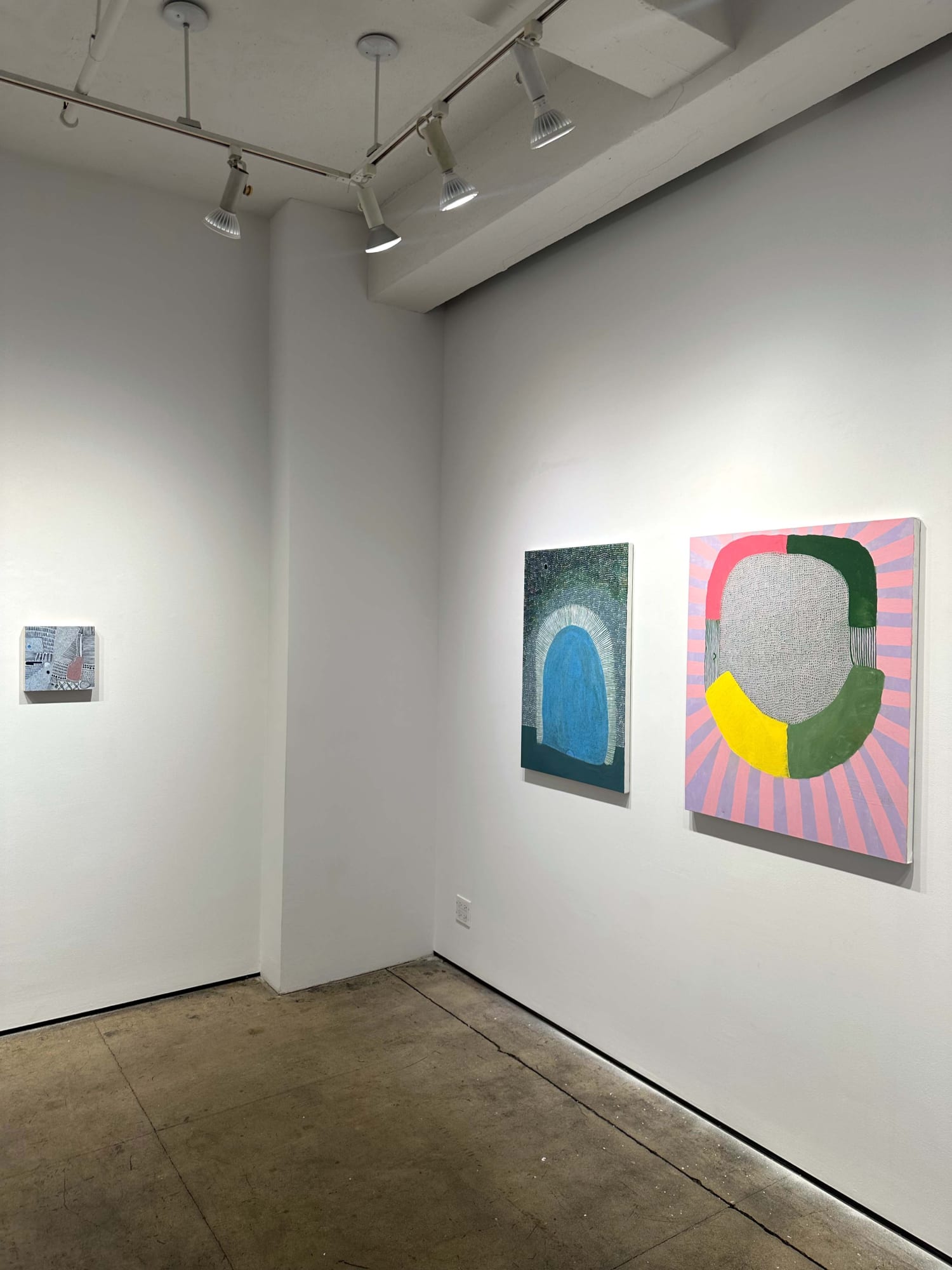 exhibition with three abstract paintings on the walls