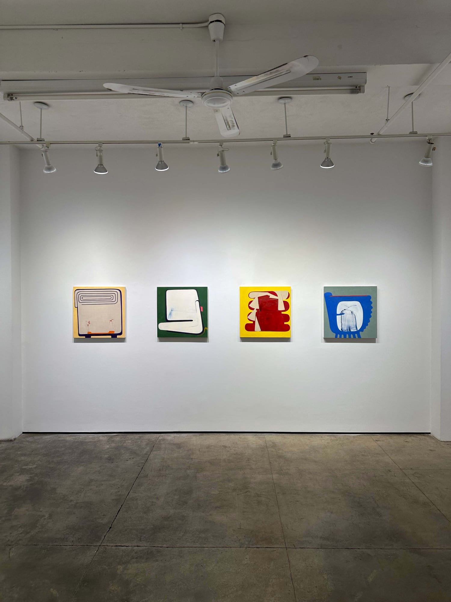 exhibition with four paintings of equal size on a wall