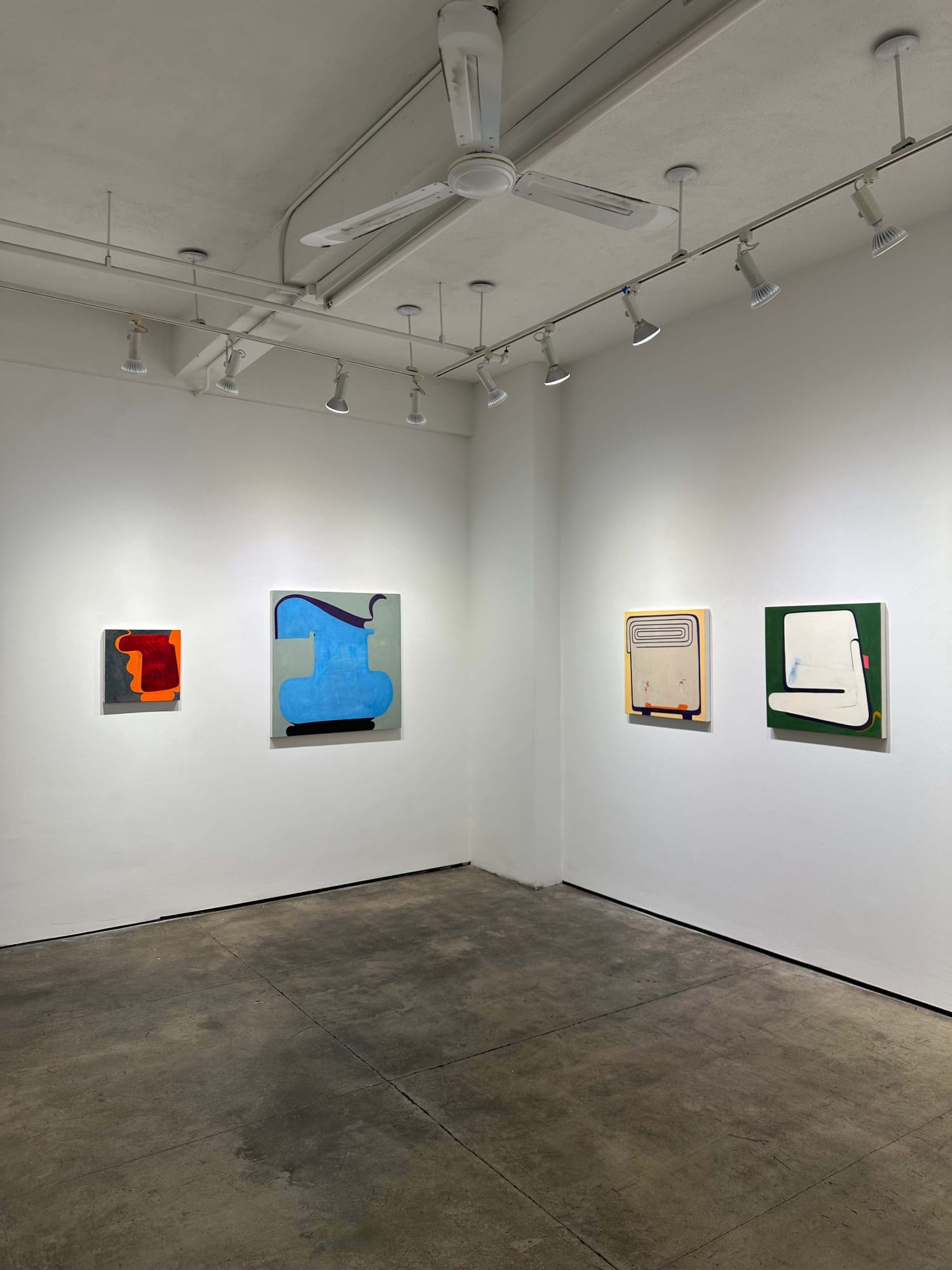 exhibition with four abstract paintings on the walls
