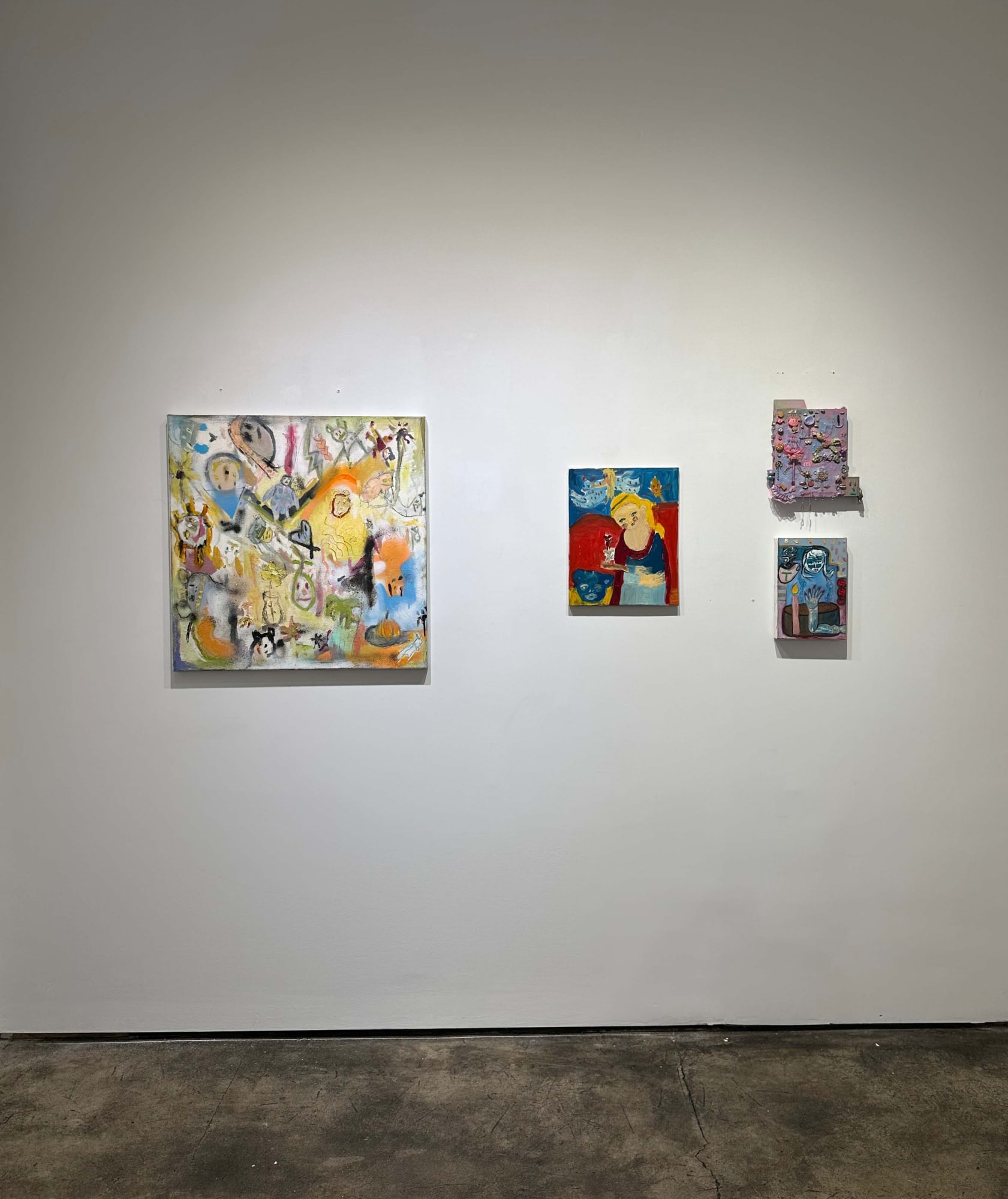 exhibition with one larger abstract painting on the wall, with three smaller works beside it