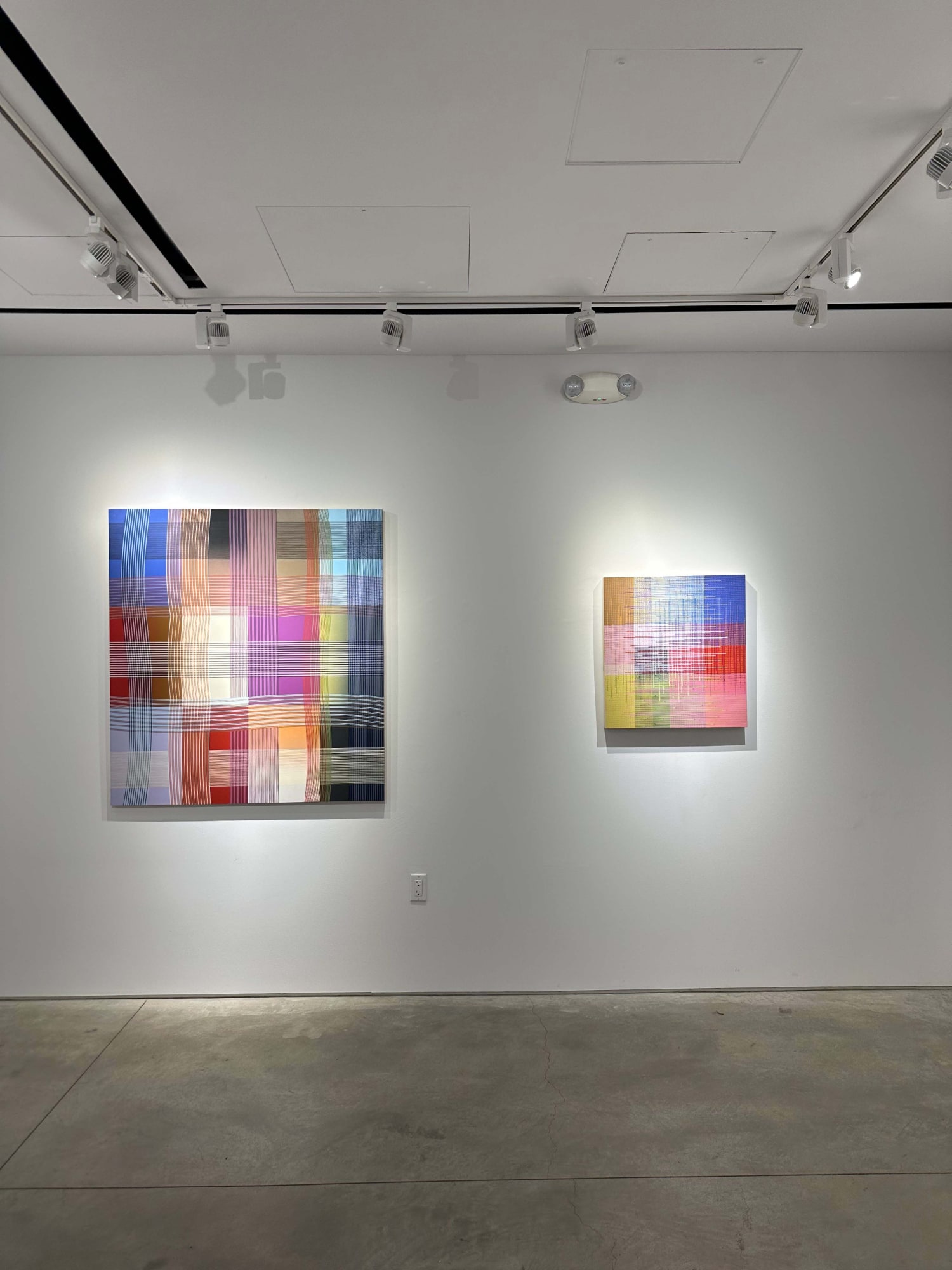 photo of an installation with two abstract paintings visible.