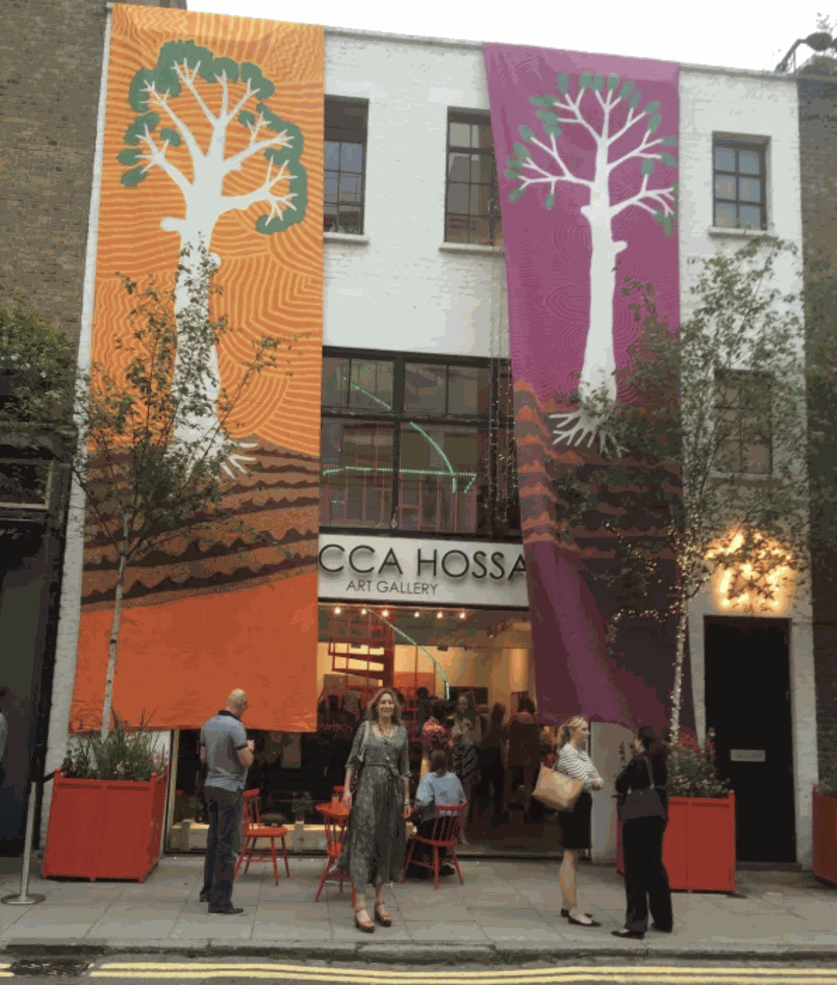 Rebecca Hossack outside the gallery with Jimmy Pike's banners