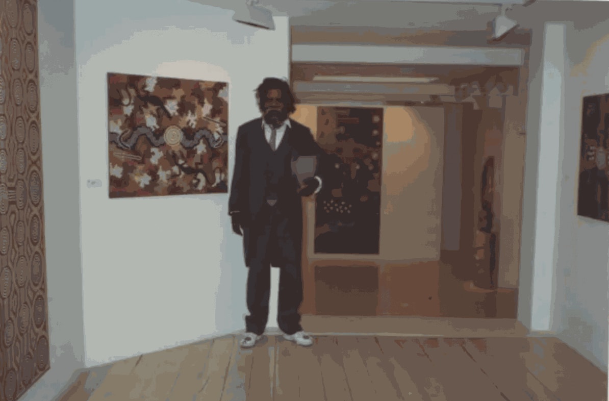 Clifford Possum wearing hand-painted shoes at the Rebecca Hossack Art Gallery, 20 March 1990
