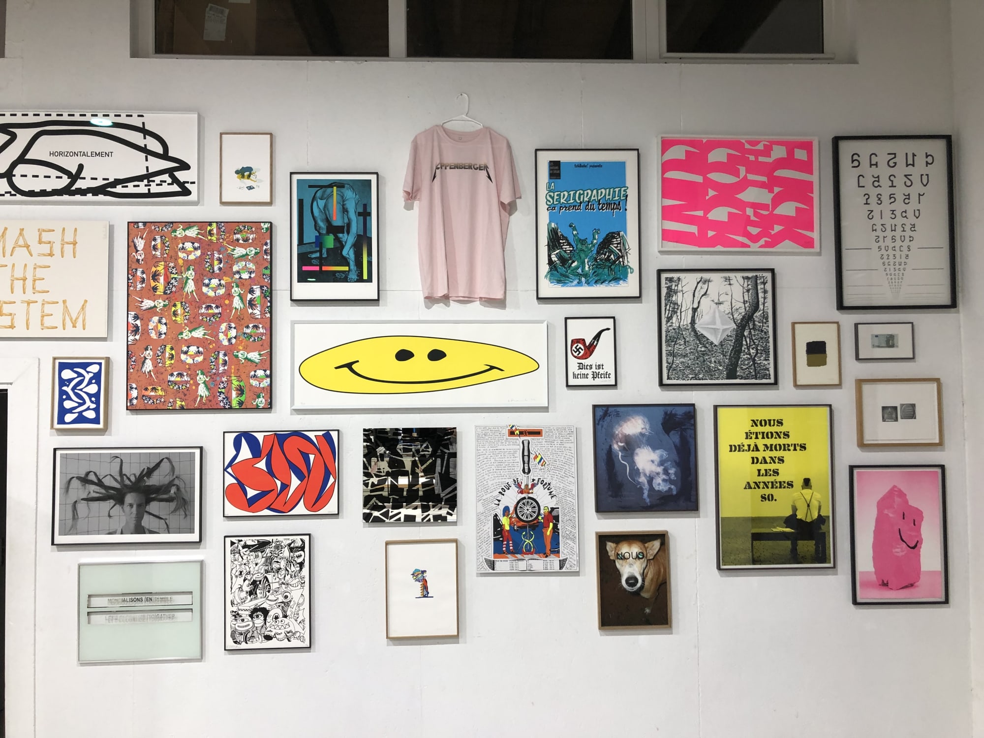 Accrochage d'œuvres d'art et d'éditions encadrées avec baguettes bois massif ou baguettes aluminium dans un atelier d'art de Marseille