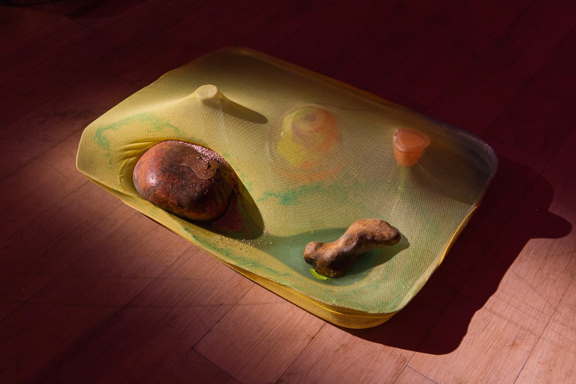 Samara Scott Slut, 2014 Baking tray, Sprite, tights, wrapping paper, fabric dye, glass, coloured sand, turmeric, foil, potatoes, balloons, spray paint, shot glass, bath salts, potpourri