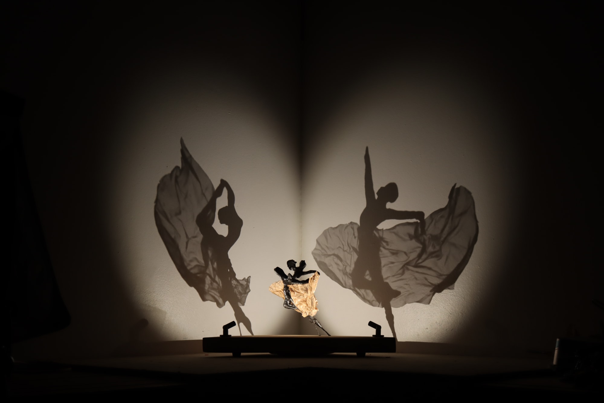 Contemporary sculpture by Will Budget, that projects two dancing ballerinas as shadows on to wall. Turner art perspective. essex gallery.