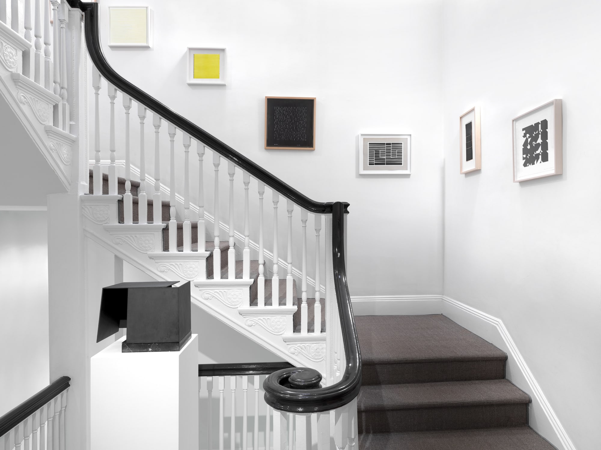 Jorge Oteiza's sculpture Caja Metafisica (1972-1974) on the front. Works on paper by Sol LeWitt, Willys de Castro, Anni Albers, Helio Oiticica, Lygia Clark, and Elena Asins on the staircase's walls.