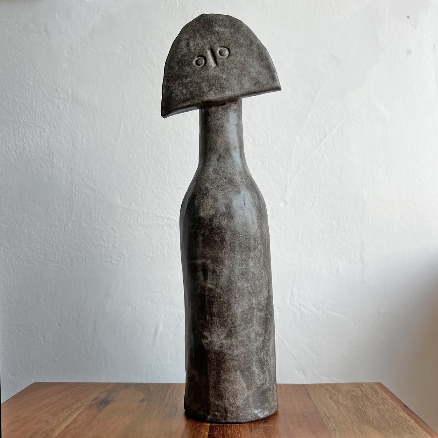 Peter Slight Cycladic ceramic figure with smoky grey speckled glaze and a tilted semi circle head with two engraved circles for eyes