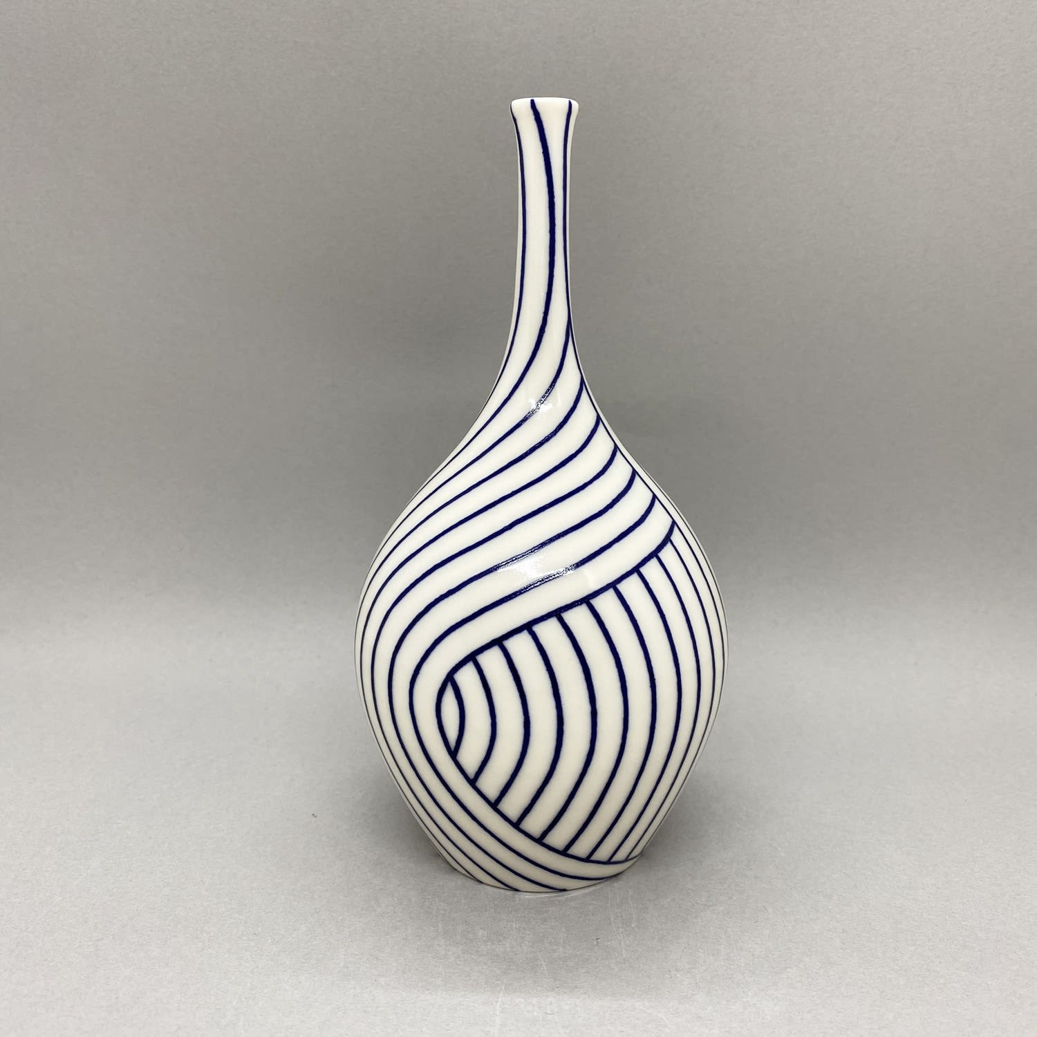 Rhian Malin medium white bottle vase with layered blue lines design.