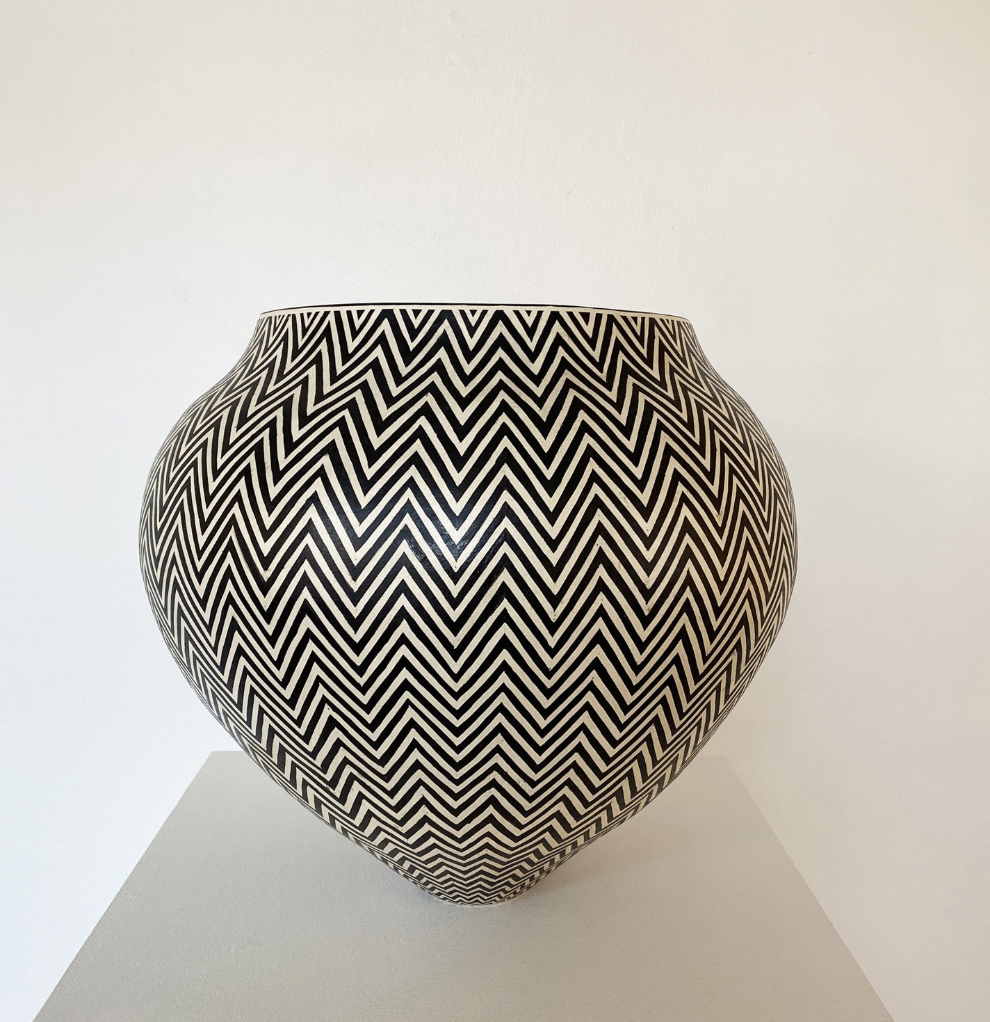 Tydd Pottery wide, heart shaped ceramic black and white vessel with a horizontal zig zag pattern.