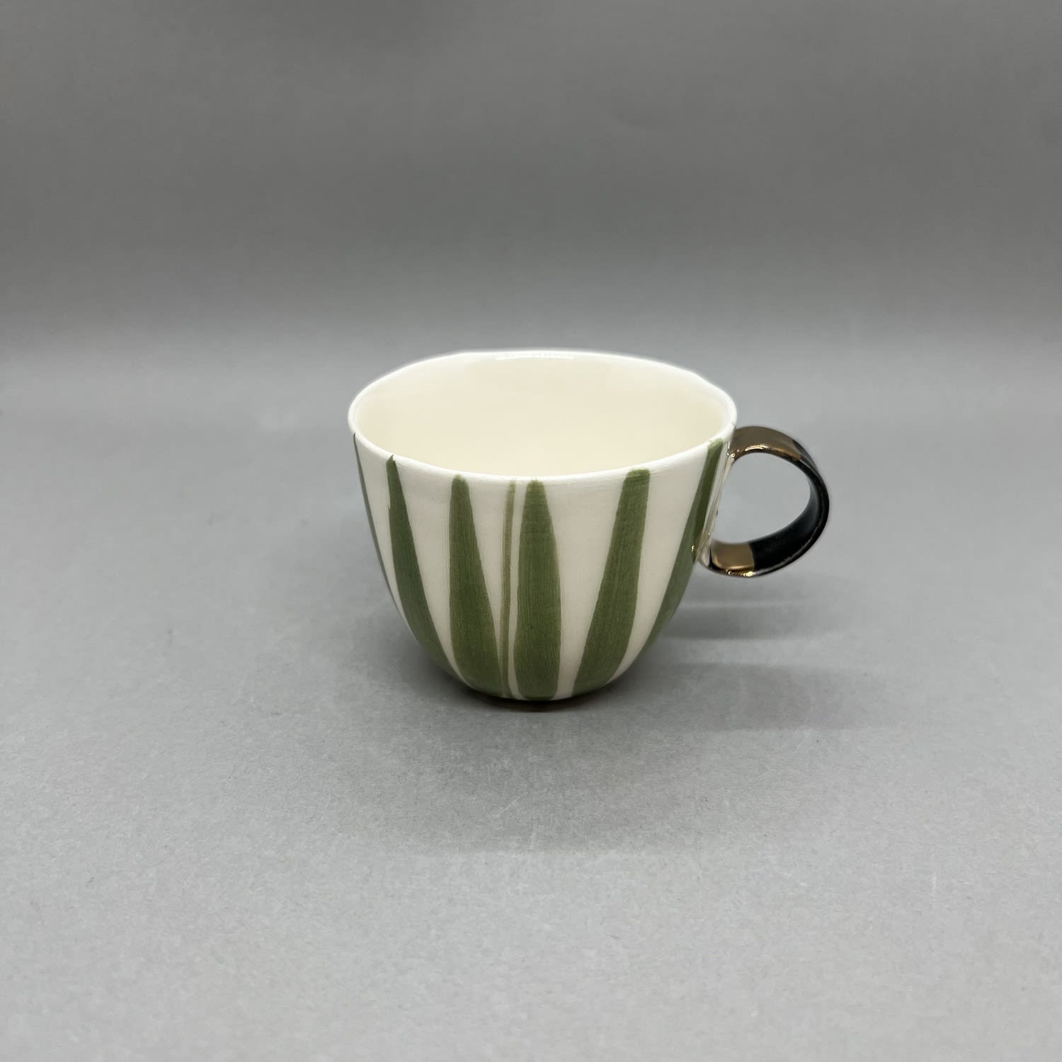 Fliff Carr ceramic espresso cup with black & gold handle with green painted lines.