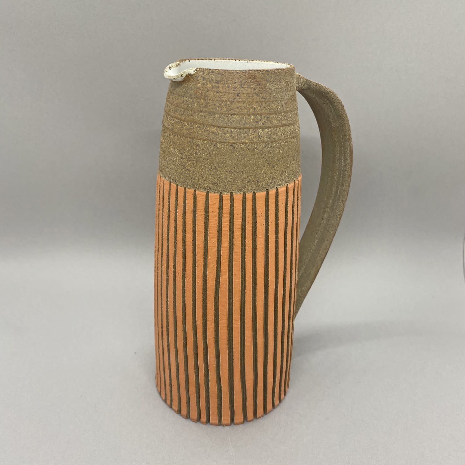 Kate Garwood tall brown jug with an orange body and vertical stripes.