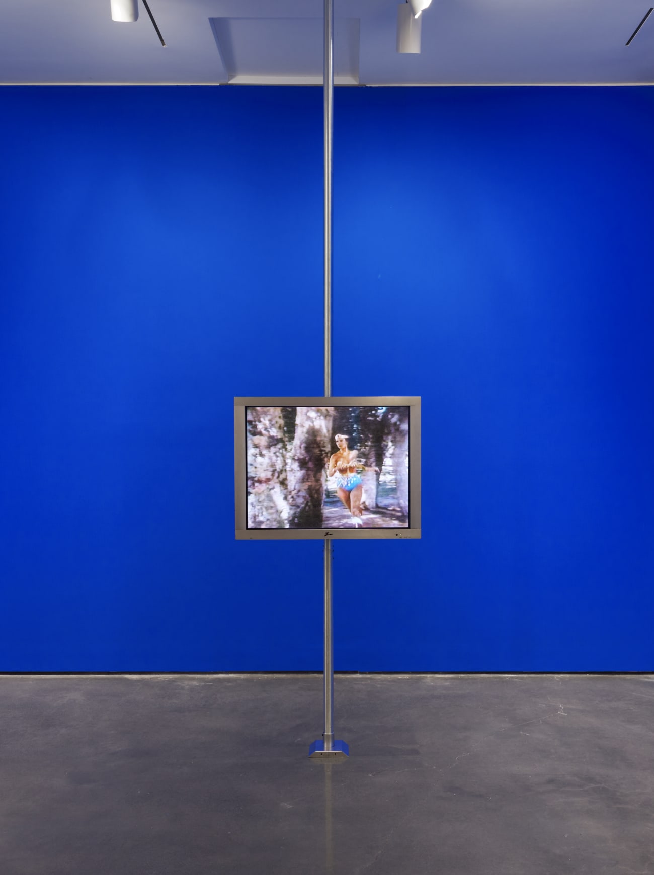Installation by Dara Birnbaum in front of a bright blue wall