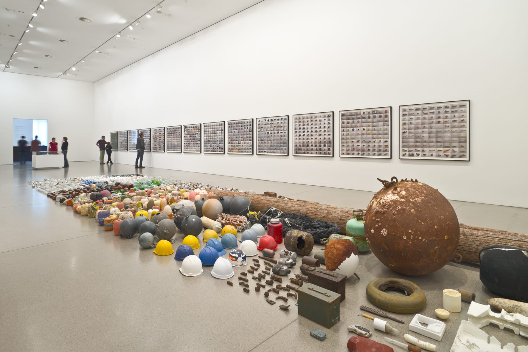 Installation view of Gabriel Orozco: Asterisms at Deutsche Guggenheim, Berlin; a series of sculptures laid across a museum floor accompanied by artwork hung on the gallery wall
