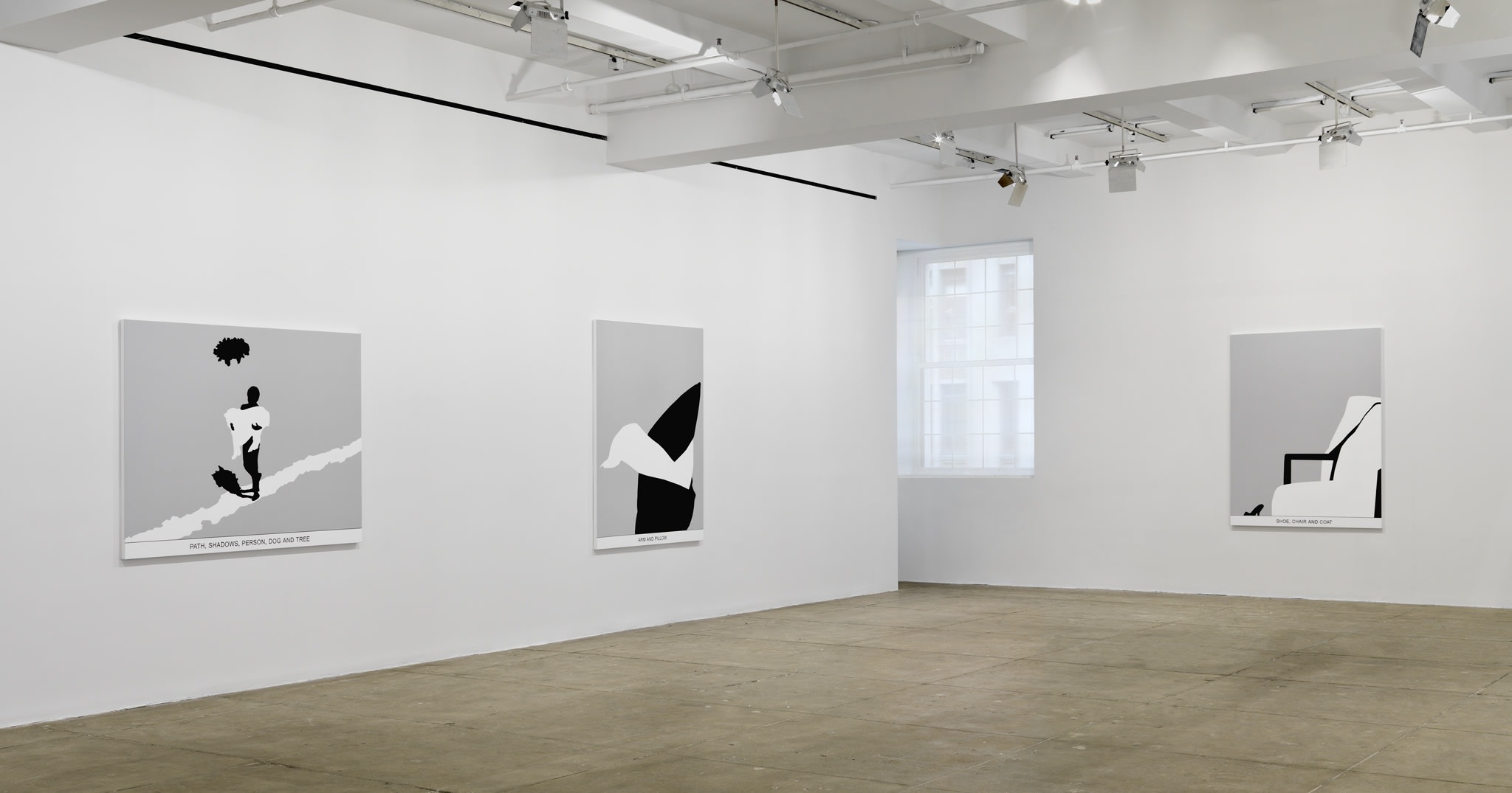 Three black and white paintings hang in a white space with a beige floor.