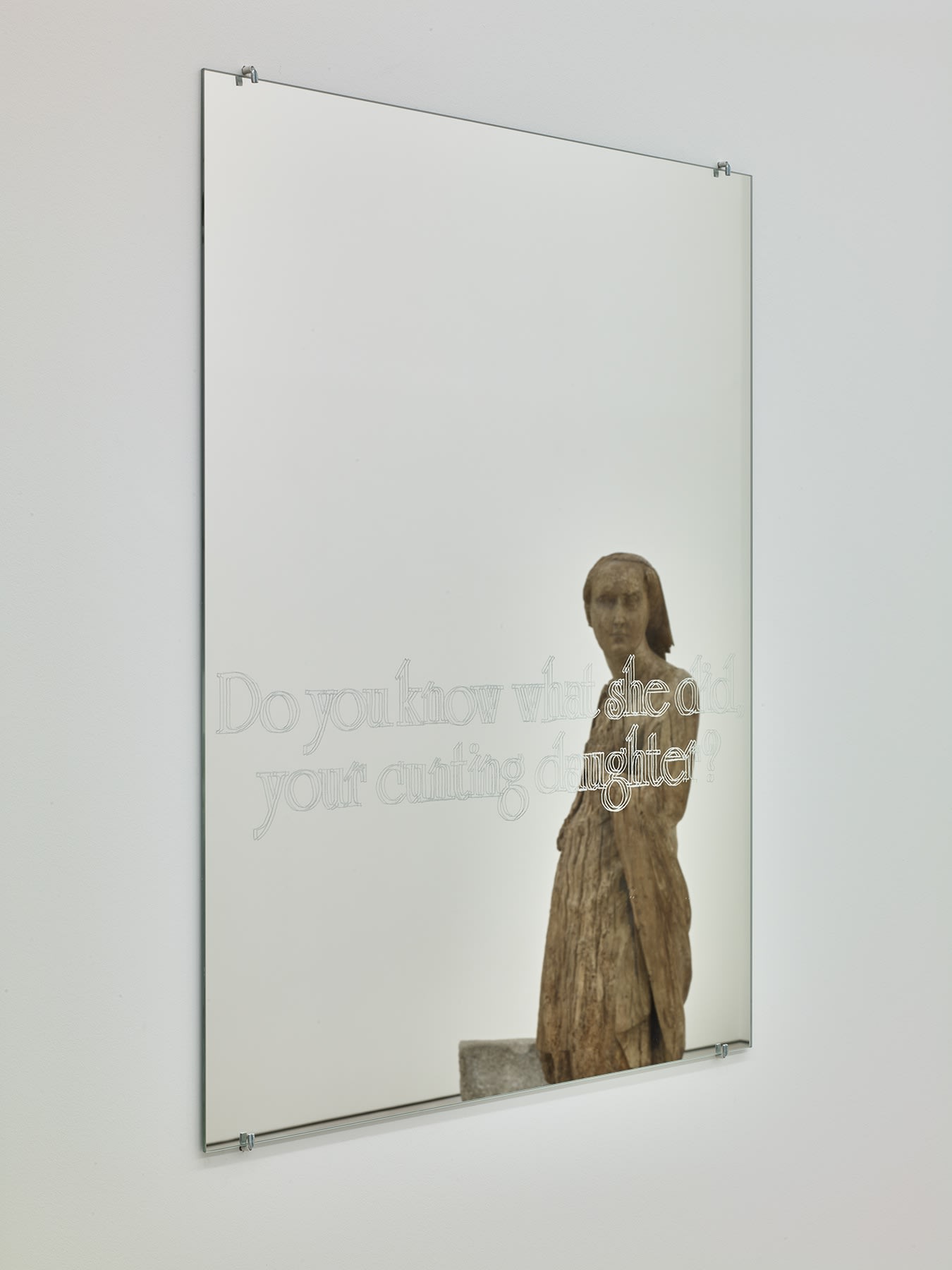 Image of mirror with translucent words reflecting a figurative statue facing the mirror.