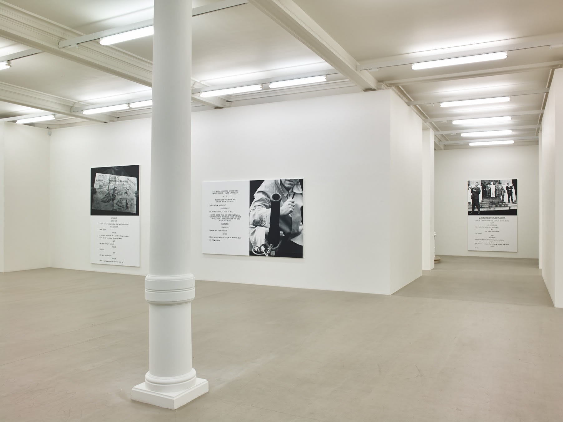 In a large white space with columns, 3 large paintings hang. Each are roughly half image and half text, which is in the format of a film script.