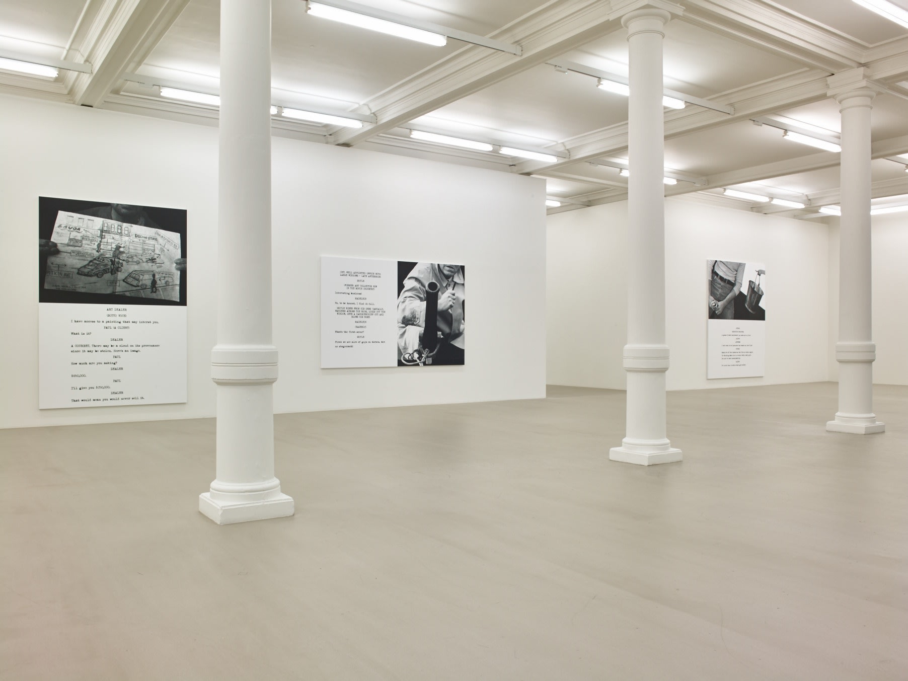 In a large white space with columns and a long skylight, 3 large paintings hang. Each are roughly half image and half text, which is in the format of a film script.