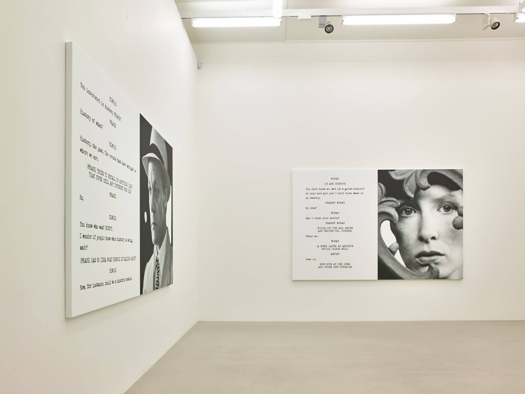 In a large white space with columns and a long skylight, 2 large paintings hang. Each are roughly half image and half text, which is in the format of a film script.