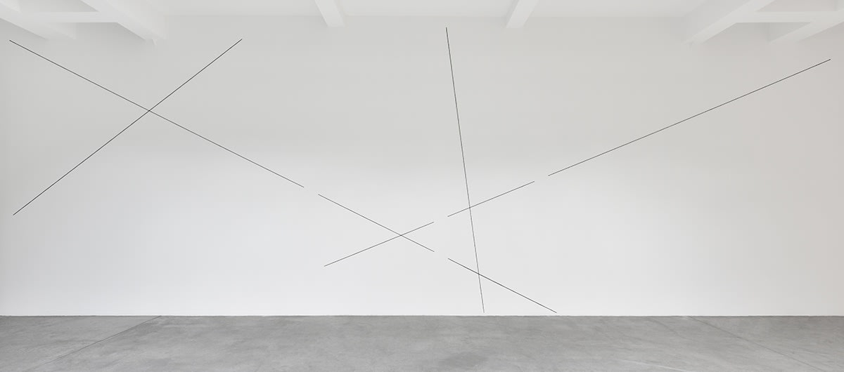 Black lines form a geometric abstract pattern on the gallery wall.