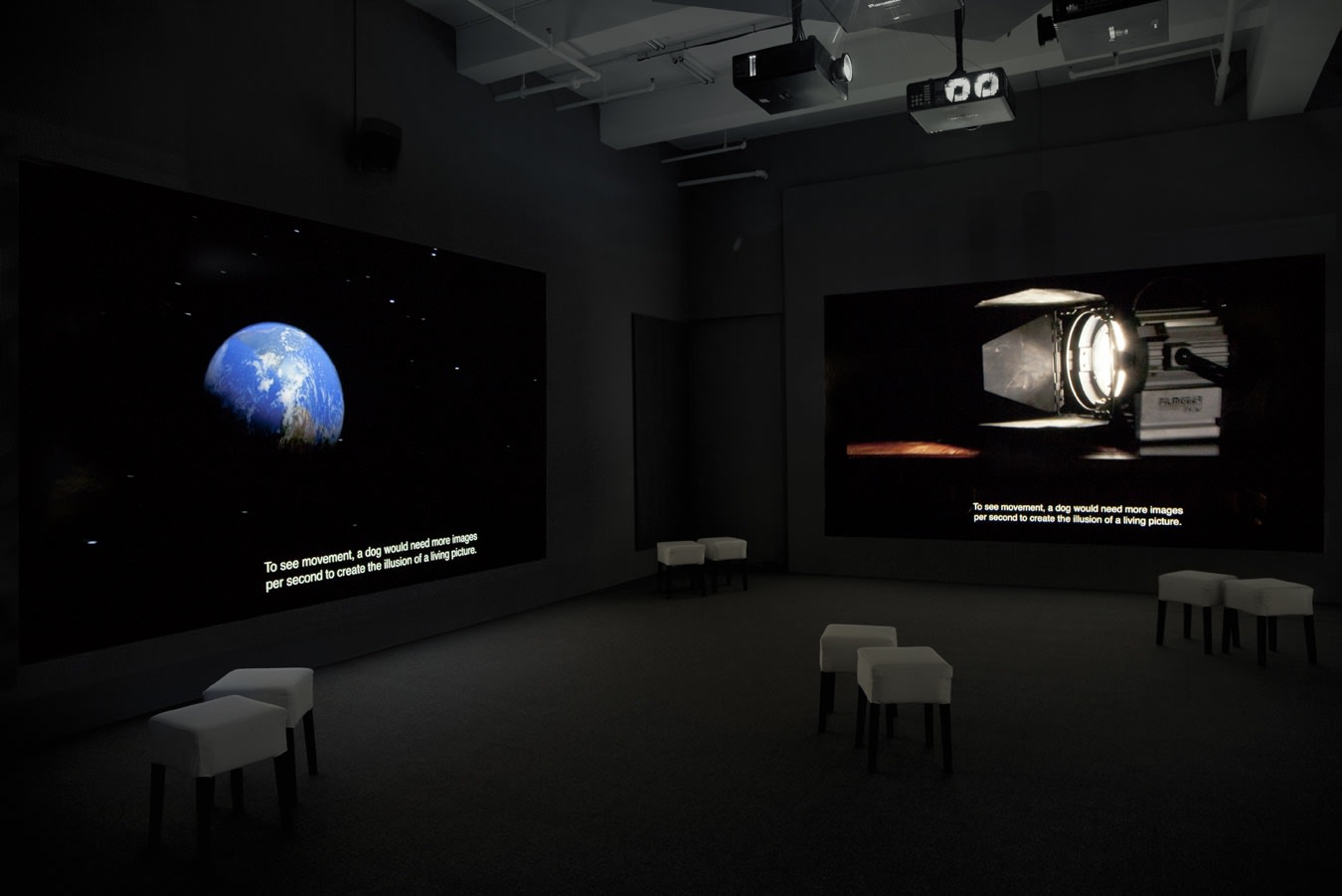 Two screens projecting space related images. The earth on the left screen and mechanics from a spaceship on the right.