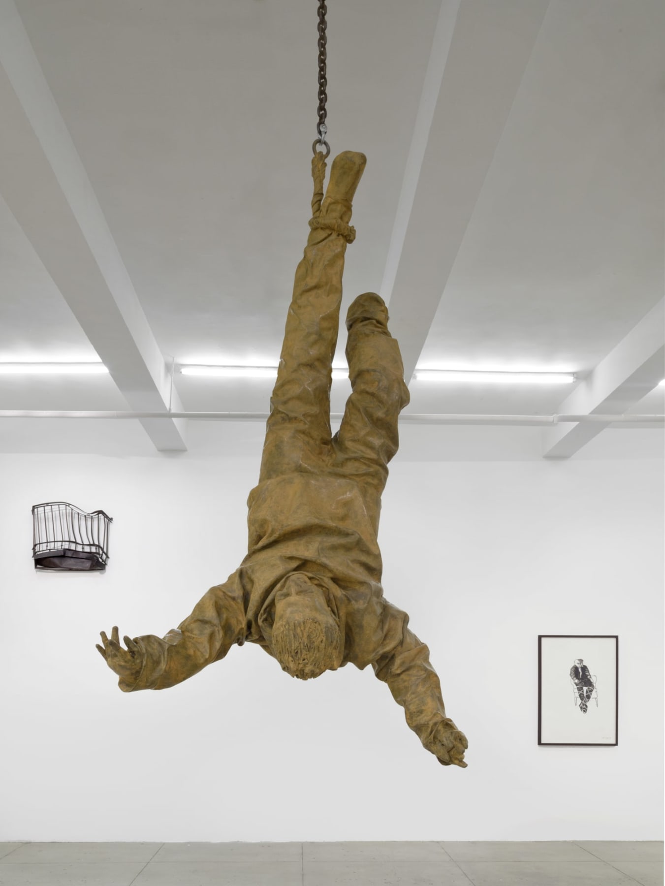 Sculpture of person suspended in air upside down by the foot
