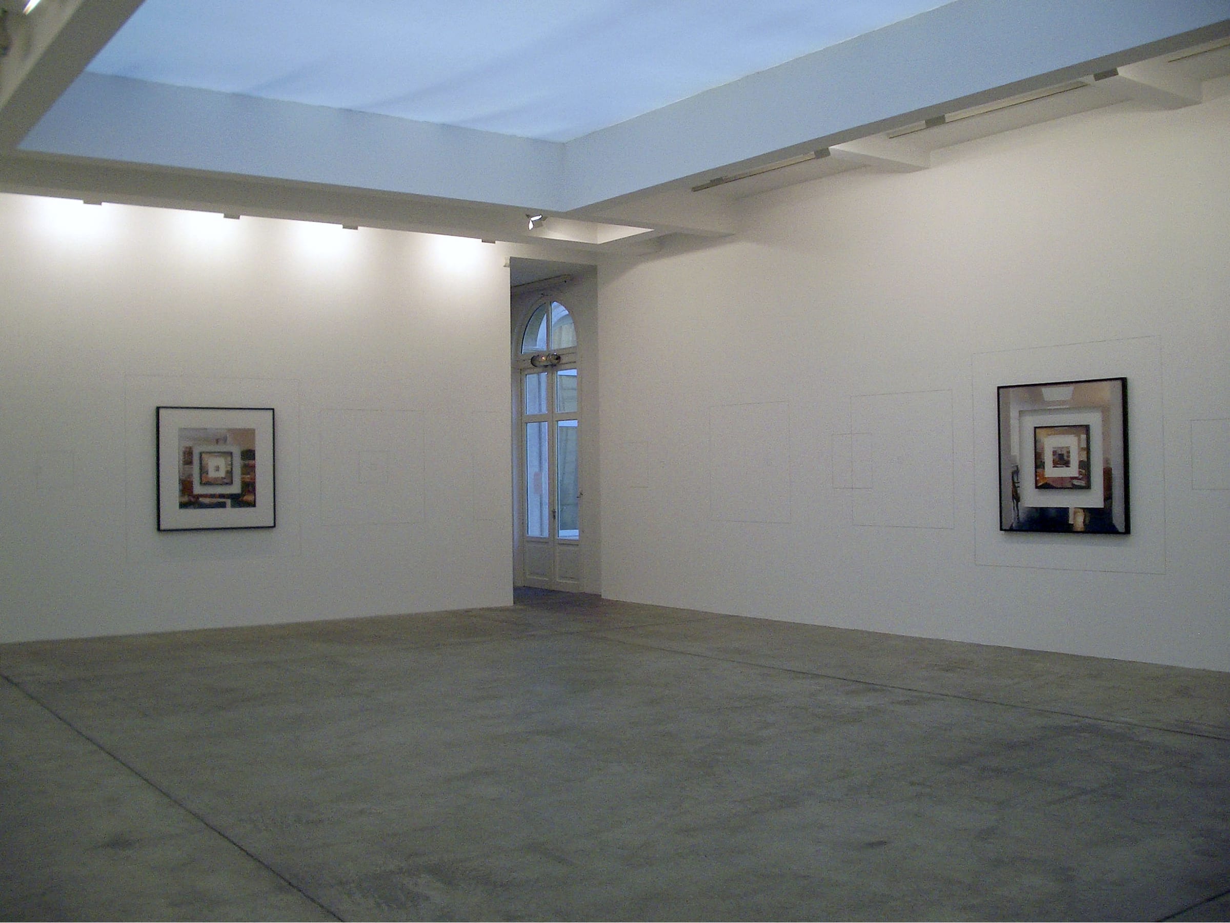 Two framed photographs on two separate walls of a gallery.